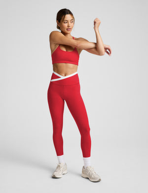 Woman wearing a red athletic outfit on a light gray background. 