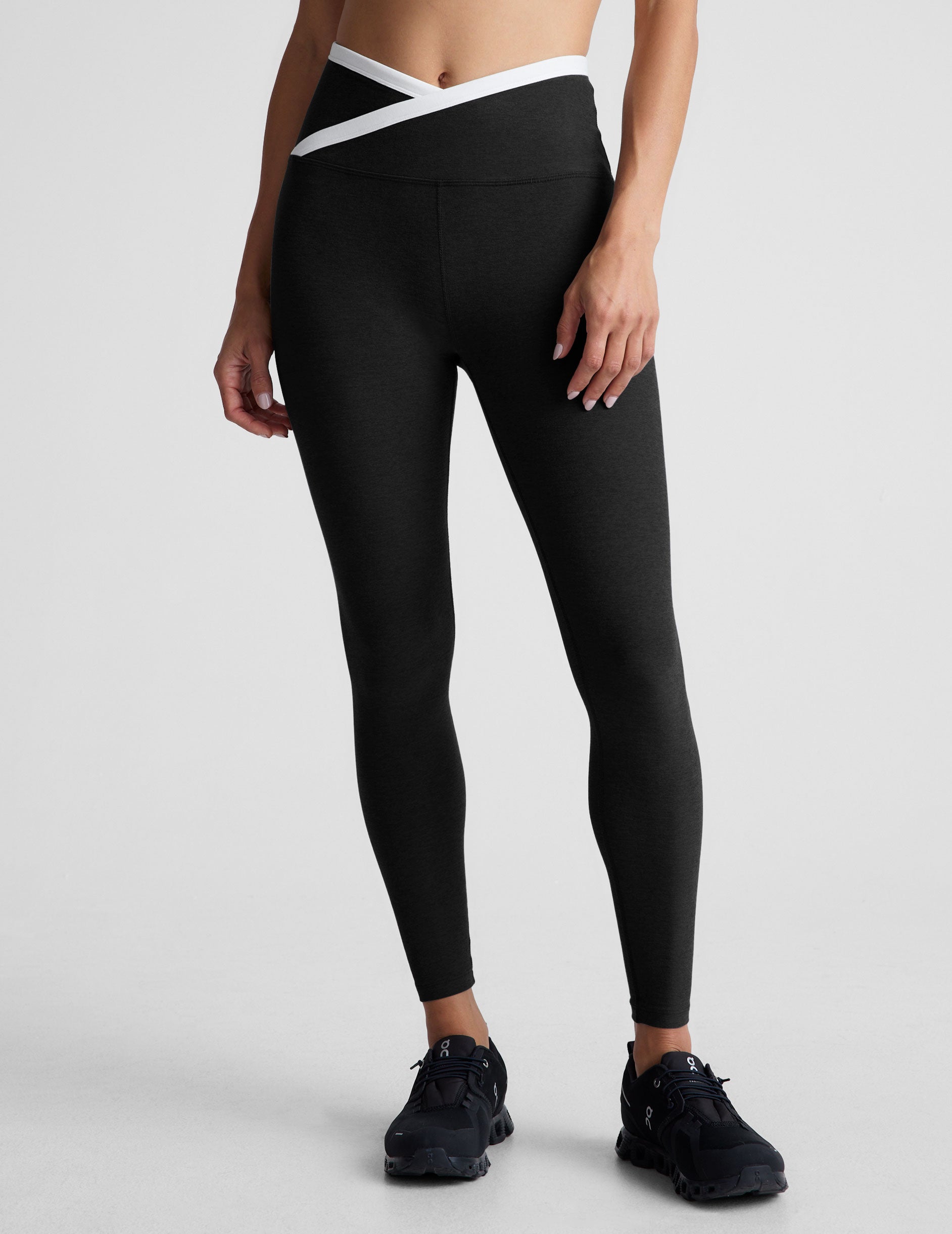 black high-waisted midi length legging with white contrast binding at crossover waistband. 