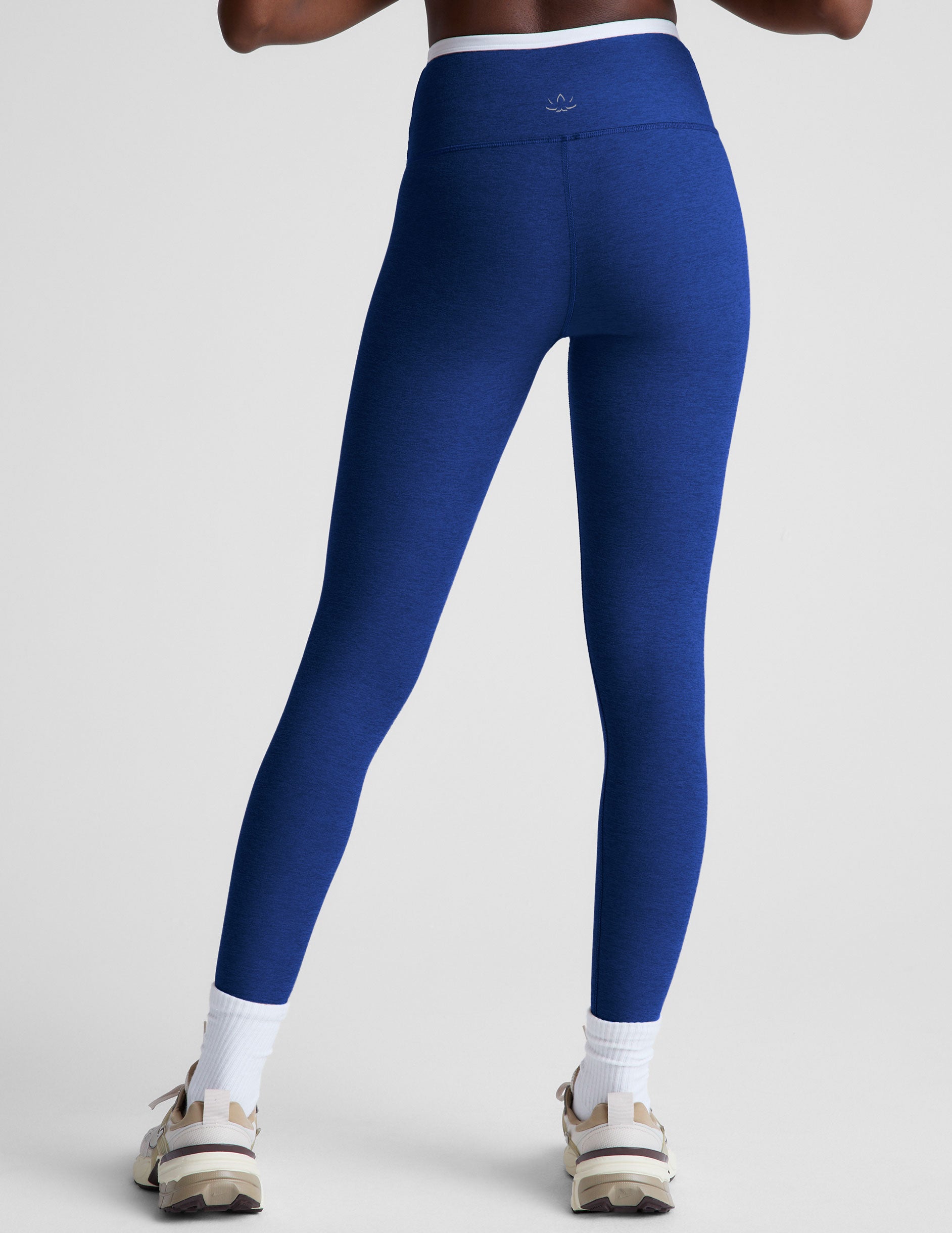 blue high-waisted midi length legging with a crossover detail on the front waistband with white contrast binding along waistline. 