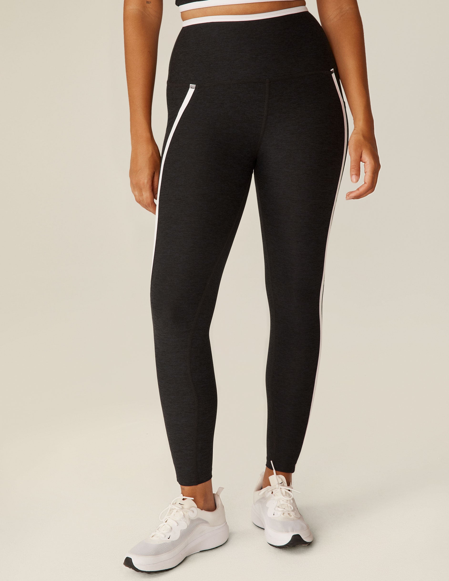 black pocket high-waisted midi legging with white lining around waistband and down the sides. 