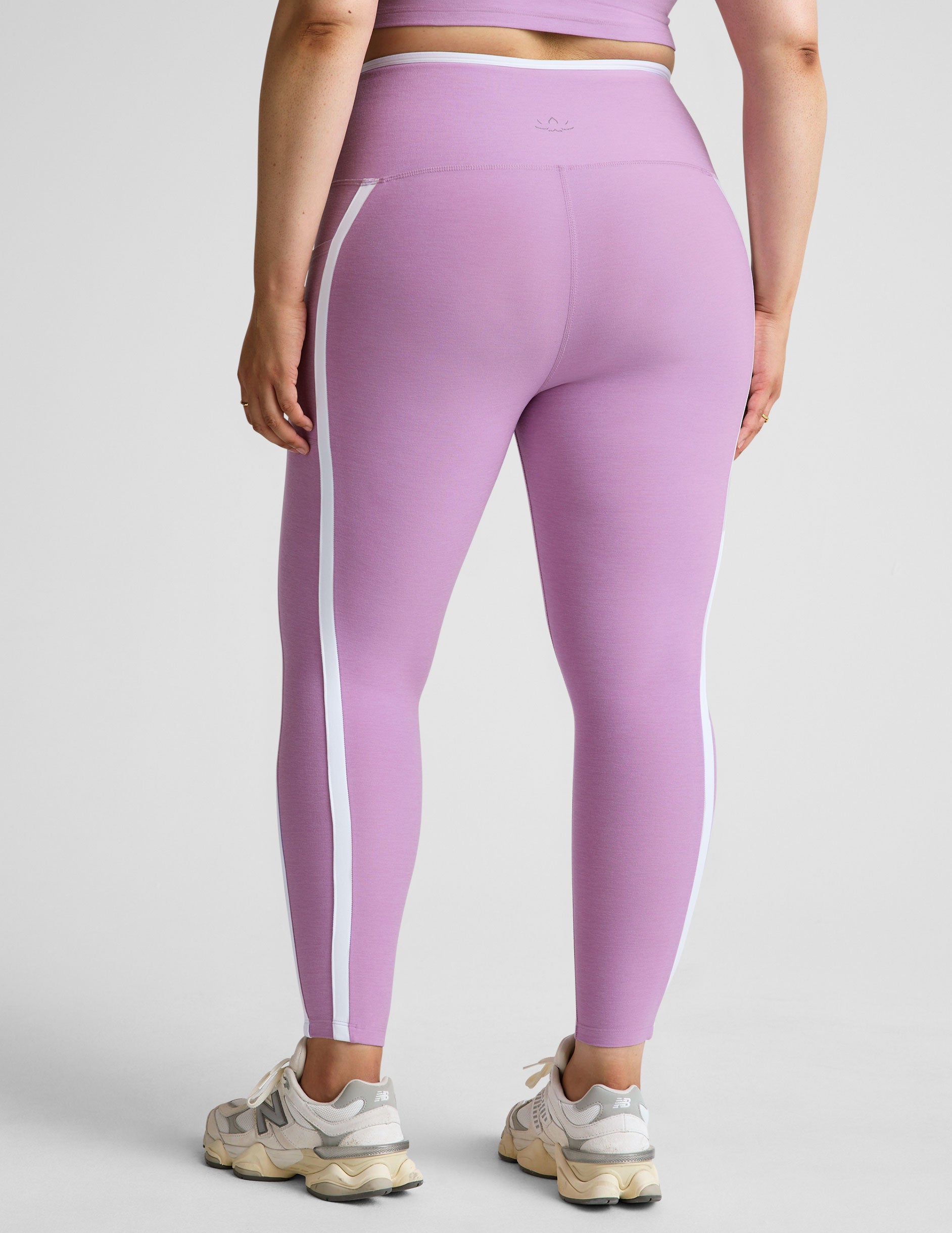 purple high-waisted midi length legging with pockets and white piping. 