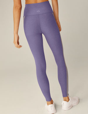 purple high-waisted midi leggings with gray trim down the side. 