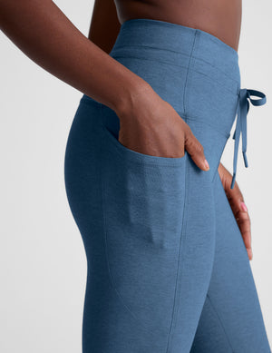blue high-waisted midi leggings with pockets and a drawstring at waistband. 