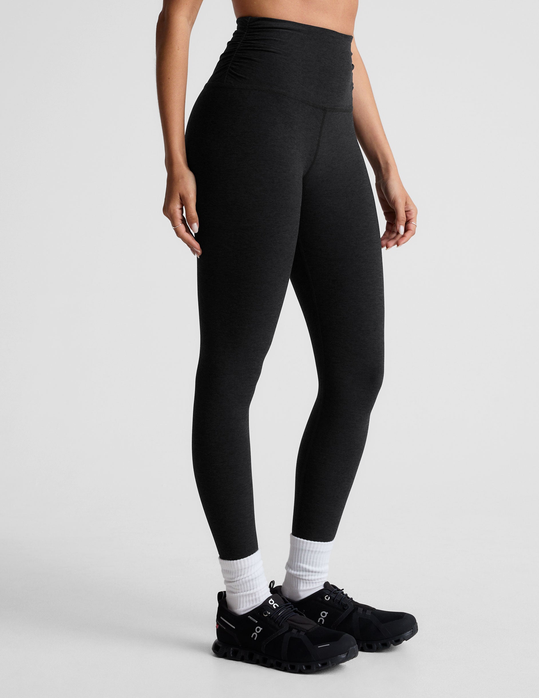 black high-waisted midi length legging with a shirred detail on the sides of the waistband. 