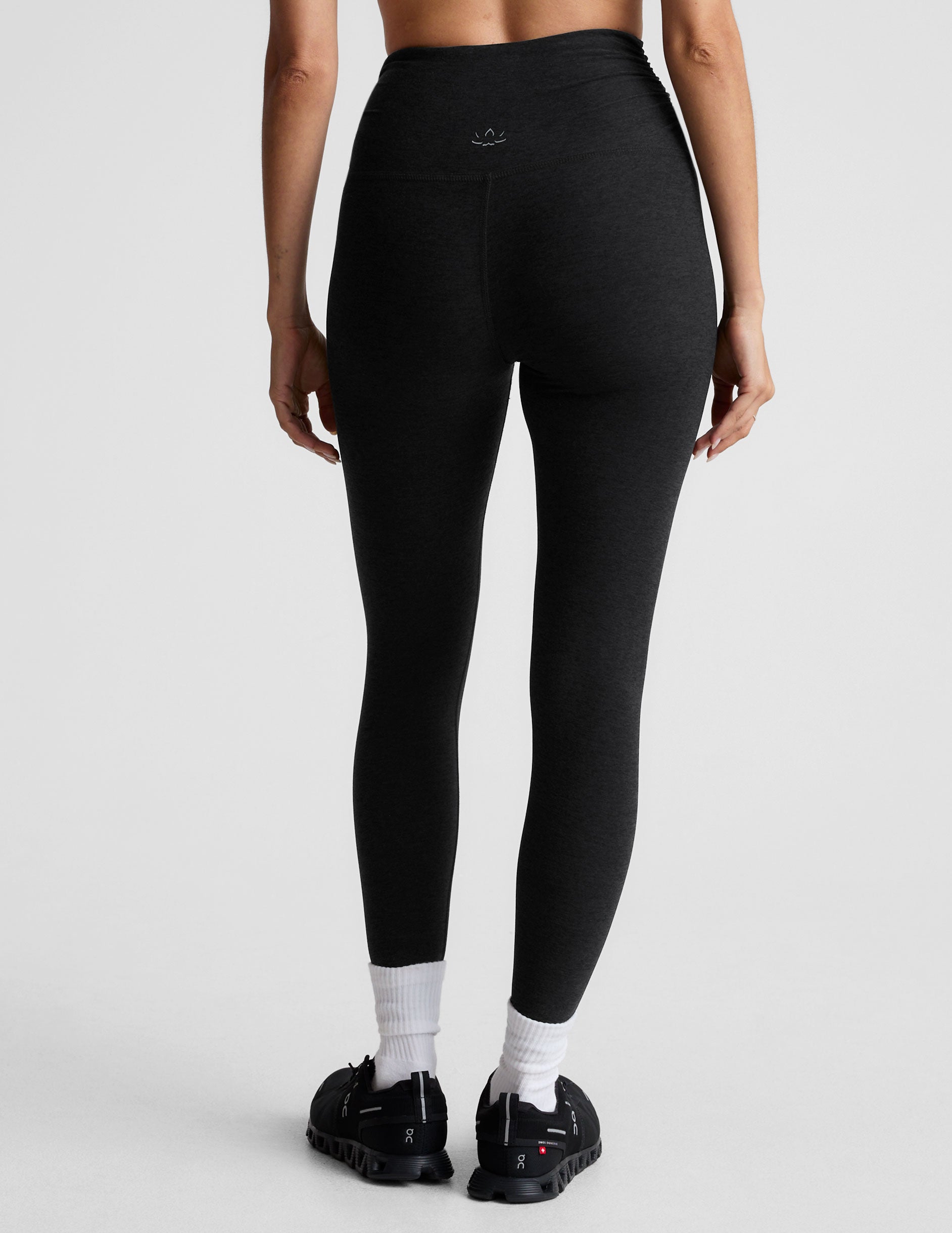 black high-waisted midi length legging with a shirred detail on the sides of the waistband. 