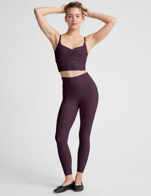 purple high-waisted midi length leggings against a plain background. 