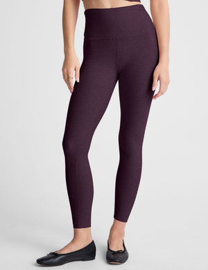 purple high-waisted midi length leggings against a plain background. 