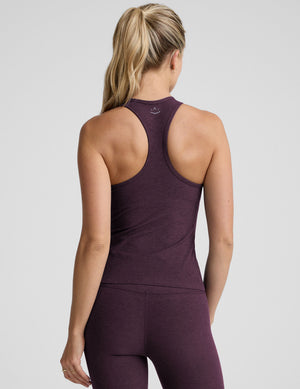 model wearing a purple racerback tank top and purple high-waisted midi length leggings. 
