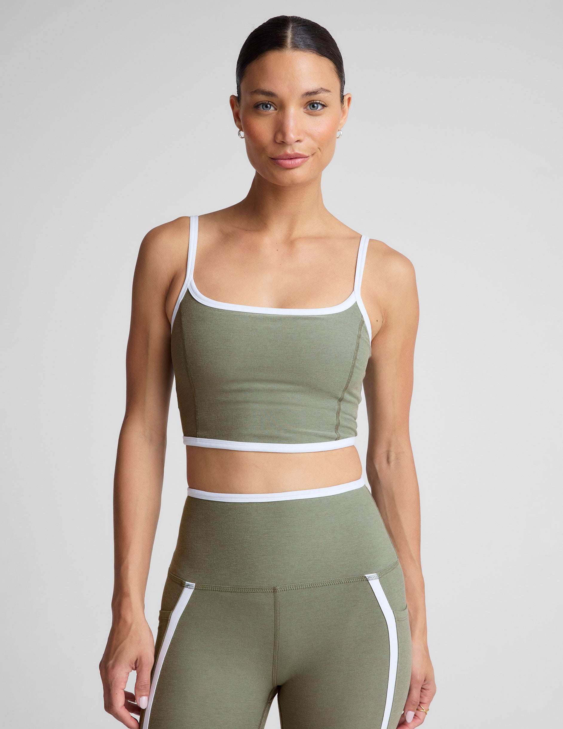 green cropped tank top with contoured princess seams and white piping detail along edges. 