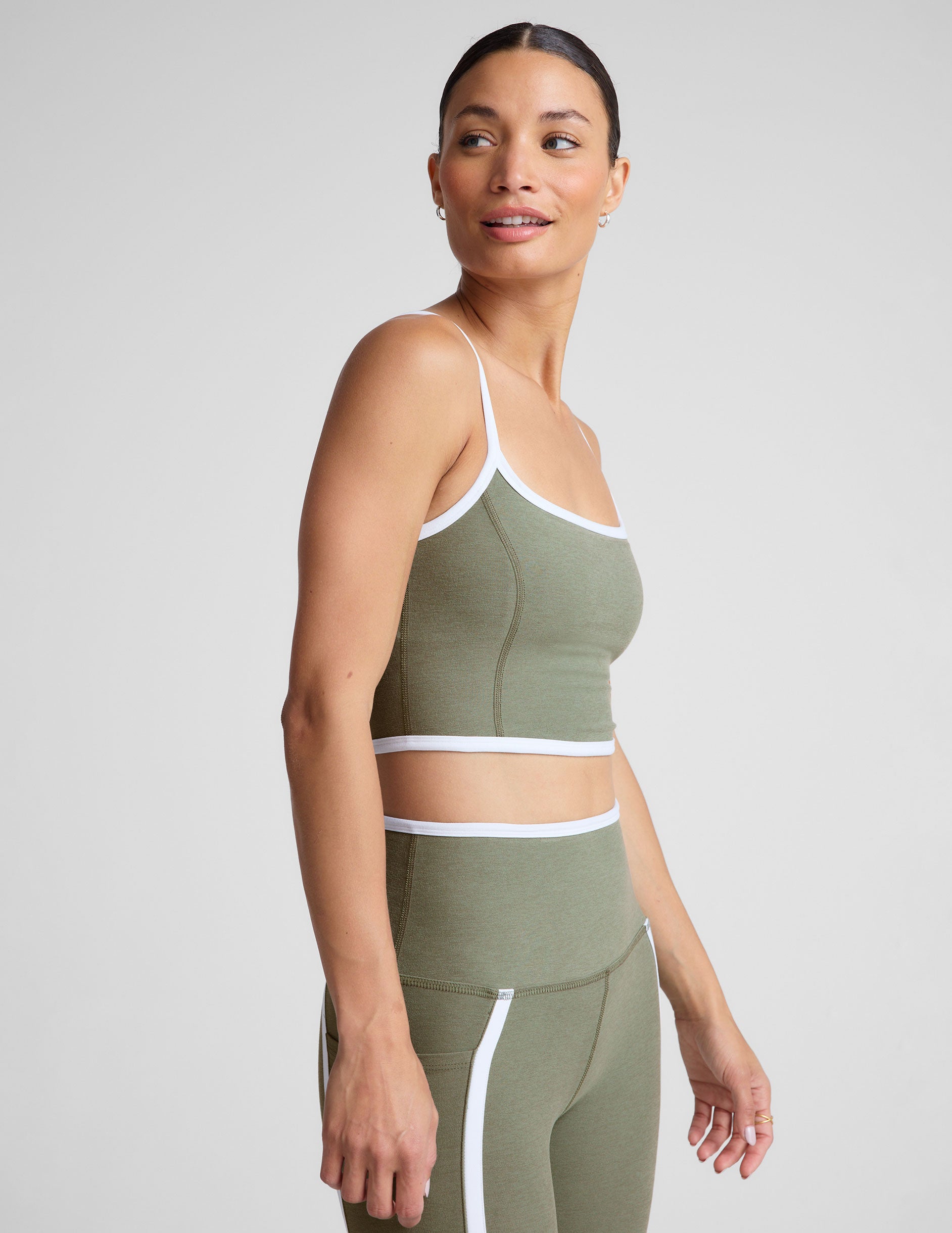 green cropped tank top with contoured princess seams and white piping detail along edges. 