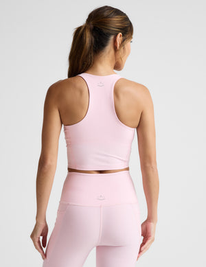 Woman wearing a pink athletic outfit on a light gray background