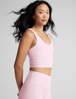 Woman wearing a pink athletic outfit with a plain background