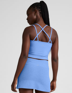 blue waist length tank top with a v-neckline and overlapping strap detail in the back. 