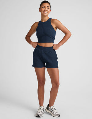 blue cropped tank with a high neck with center front zipper. 