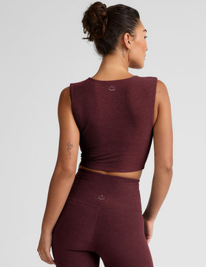 model is wearing a cropped square neck tank with thick straps. 