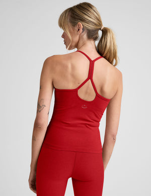 model wearing a red racerback full length tank top against a plain background. 