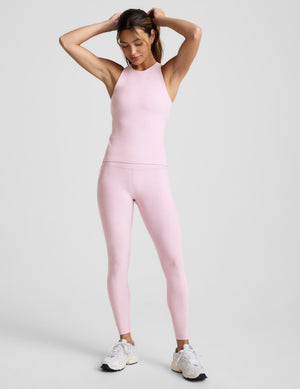 Woman wearing a pink jumpsuit against a plain background