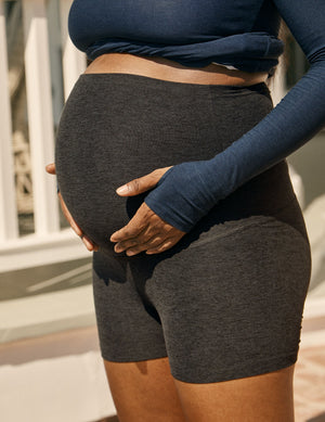 Spacedye All For Run Maternity Short in charcoal gray marled fabric, worn high over a pregnant belly with hands on bump.