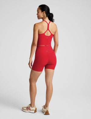 Woman wearing a red cropped tank and 5