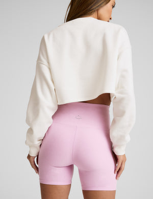 Woman wearing a white sweatshirt and pink 5