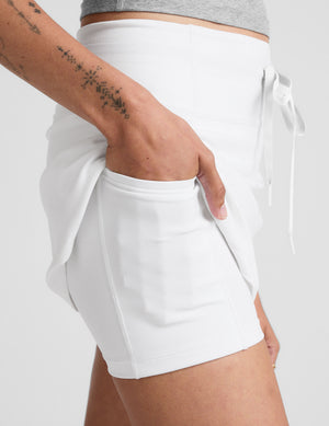 white mini skirt with a drawstring at waistband and built in shorts with pockets. 