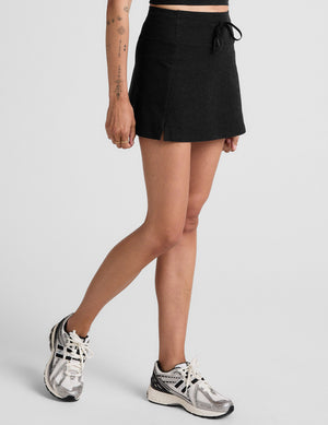 black mini active skirt with a drawstring at waistband and built in shorts with pockets. 