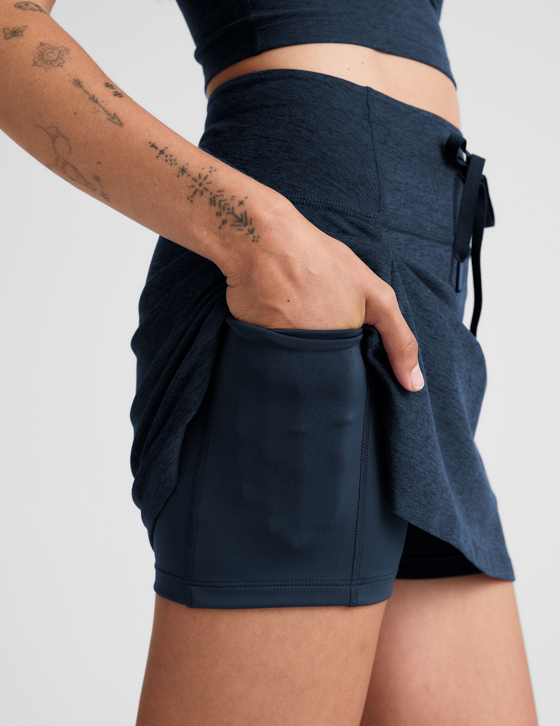 blue mini active skirt with a drawstring at waistband and built in shorts with pockets. 