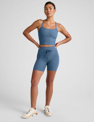 model wearing a blue athletic outfit on a light gray background. 