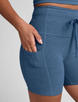 model wearing a blue athletic outfit on a light gray background. 