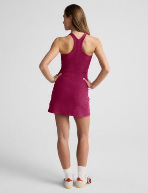 Woman wearing a red high-neck mini dress against a plain background. 