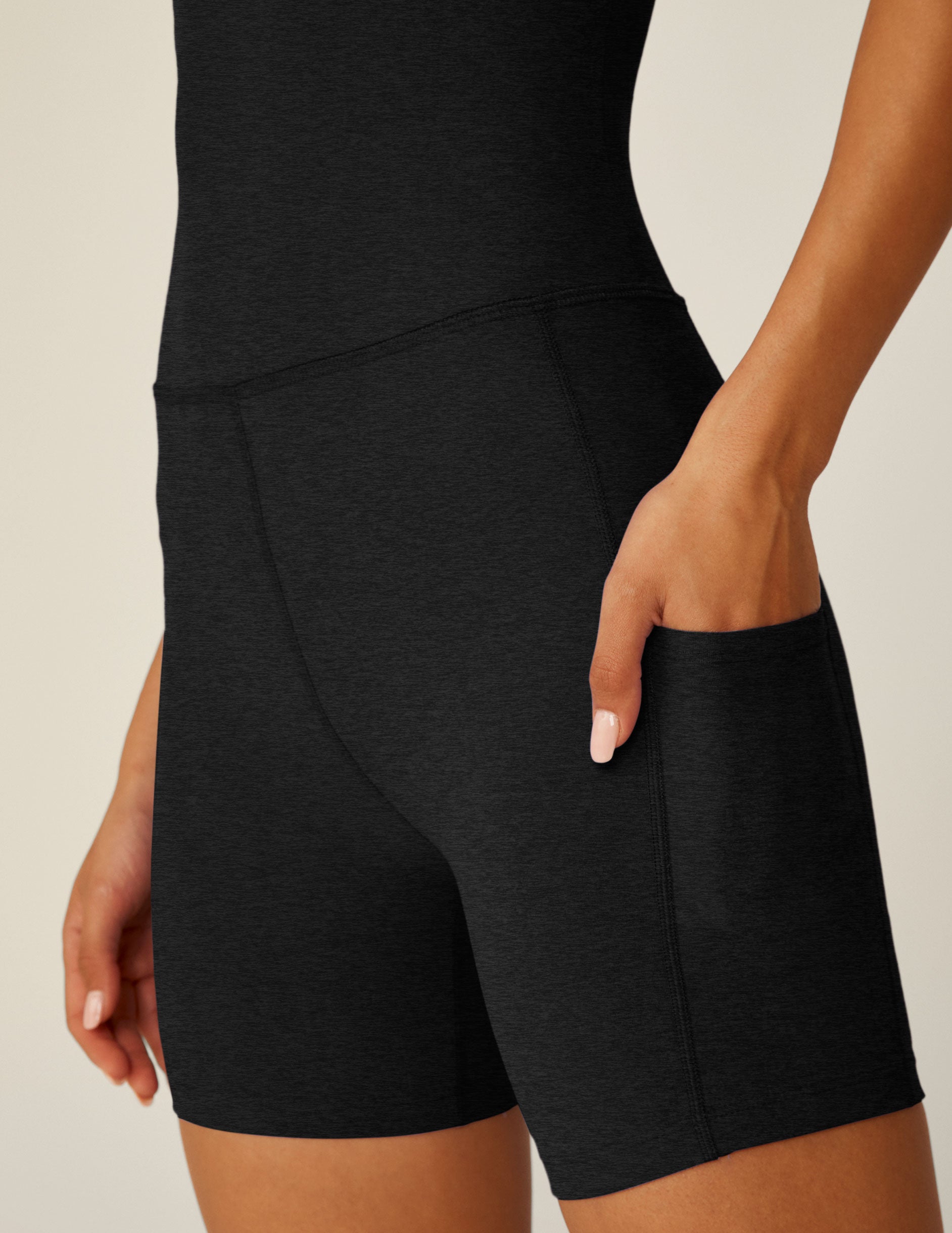 black biker jumpsuit with a crossover strap detail in the back and pockets. 