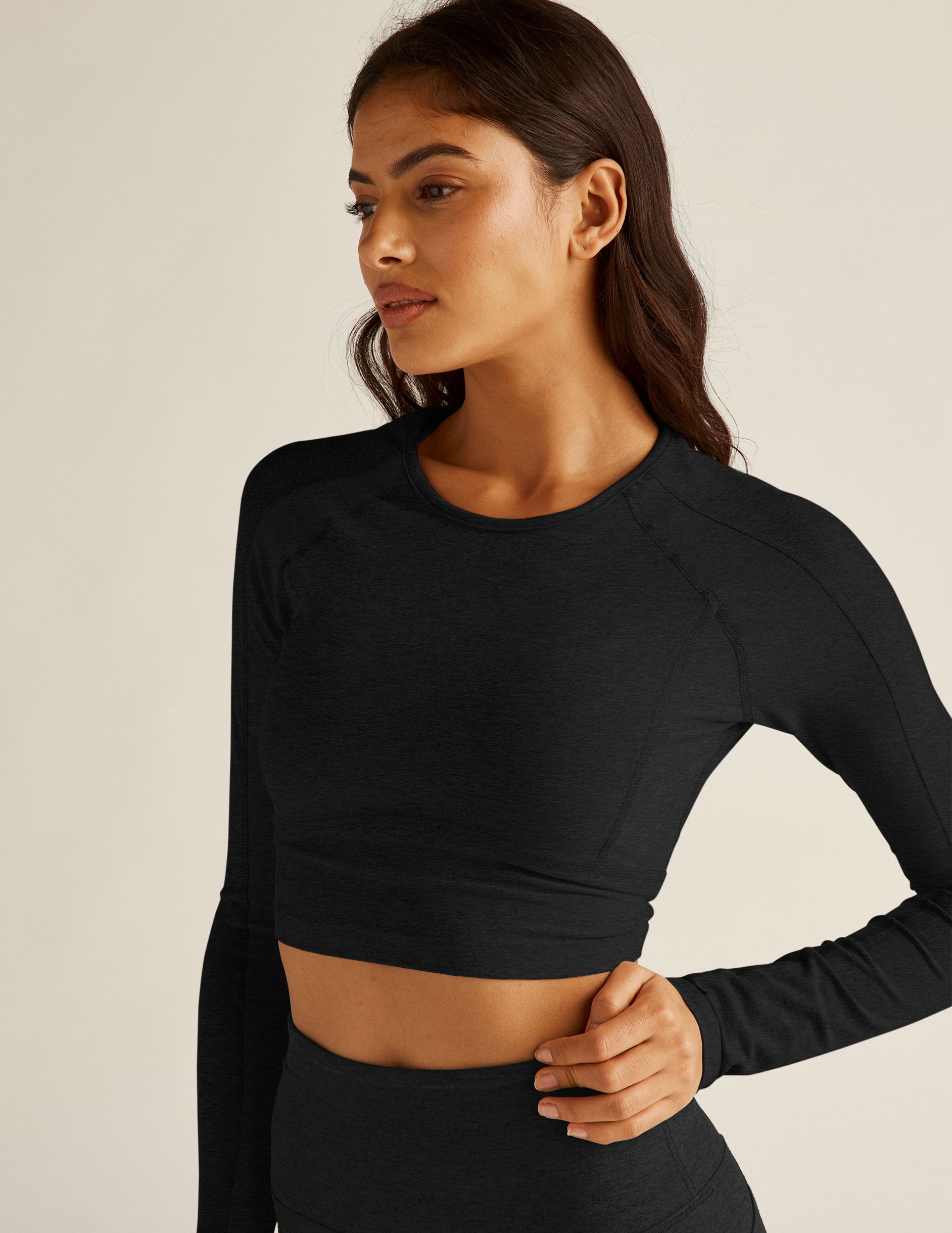 black cropped pullover with a crew neckline and thumb holes. 