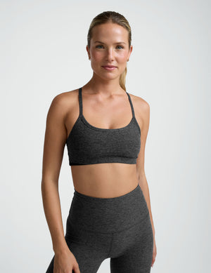 person wearing a black-charcoal slim racerback bra with matching leggings against a plain background. 