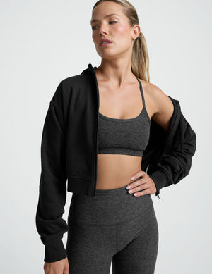 person wearing a black-charcoal slim racerback bra with matching leggings against a plain background. 