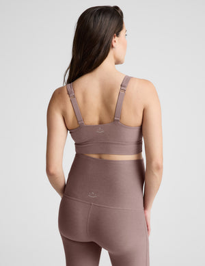 Woman wearing a brown maternity bra and pants against a plain background. 