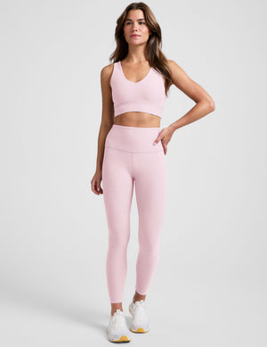 Woman wearing a pink athletic outfit on a plain background