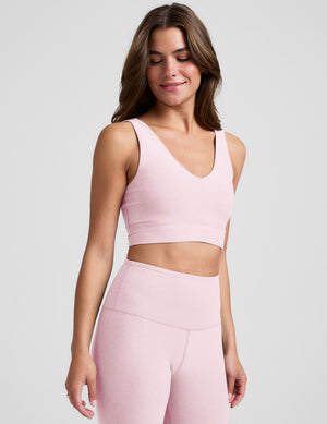 Woman wearing a pink athletic outfit on a plain background