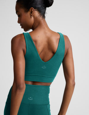 Woman wearing a green athletic outfit on a plain background. 