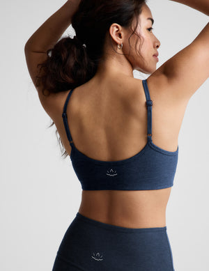 Woman wearing a blue bra and leggings against a plain background. 