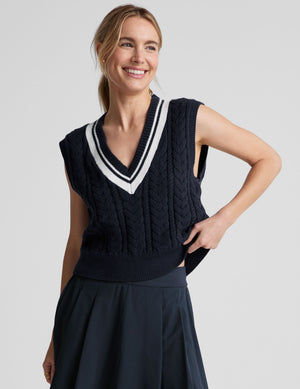 blue relaxed fit cable knit sweater vest with a v neckline with contrast color stripe. 