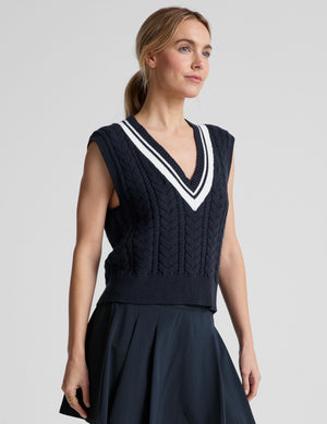 blue relaxed fit cable knit sweater vest with a v neckline with contrast color stripe. 
