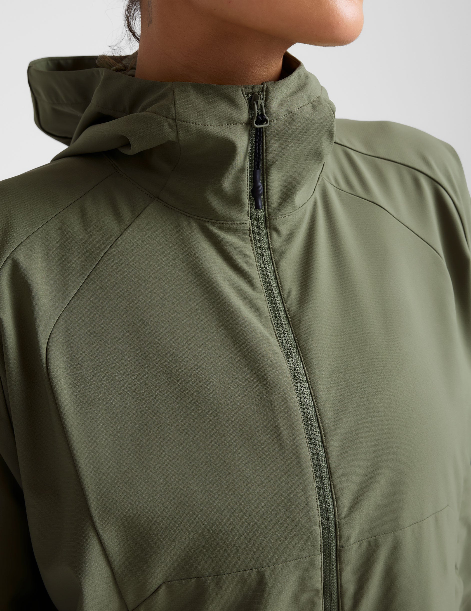 green zip-up jacket with a hood and pockets. 