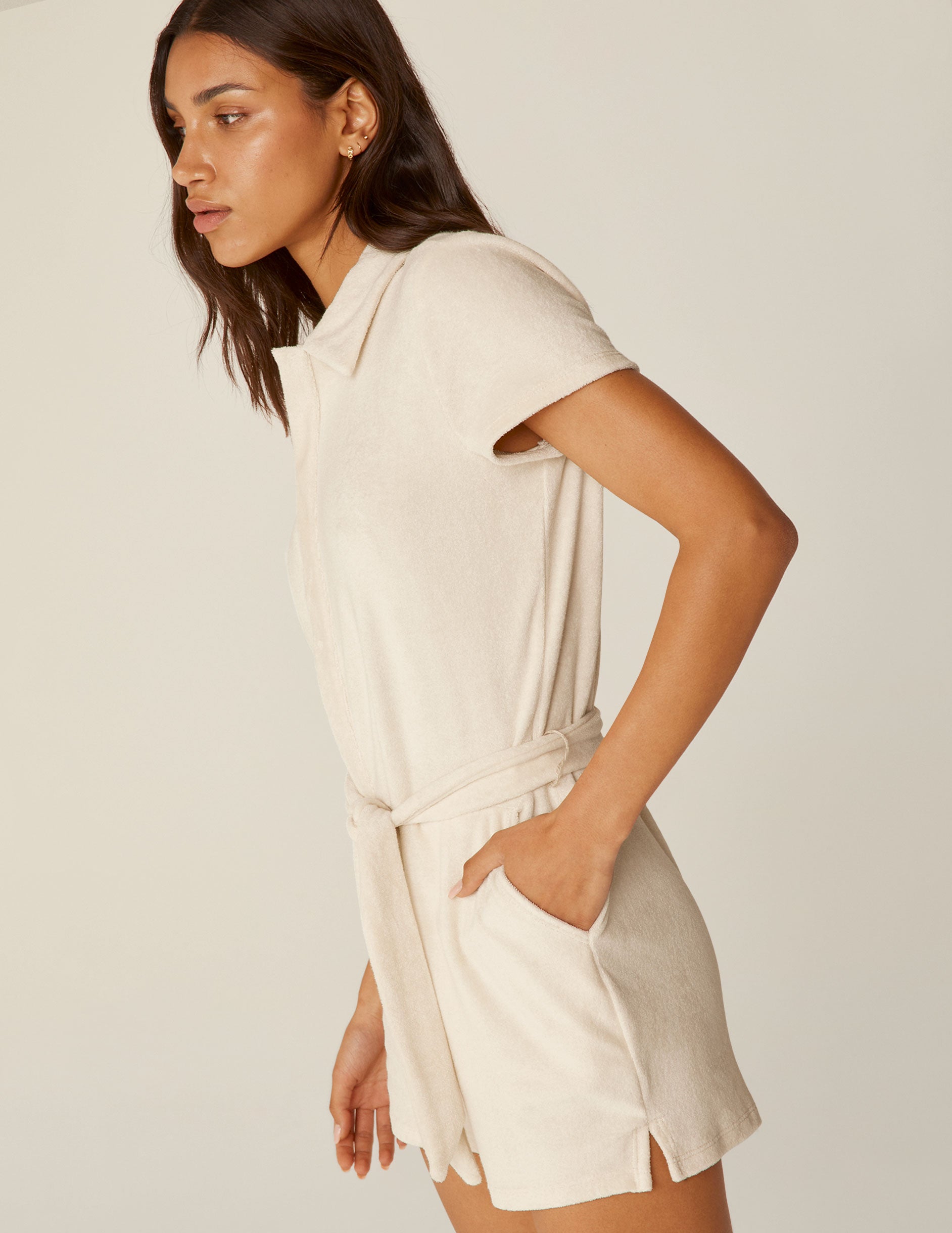 white collared terry fabric romper with a tie at the waistband.