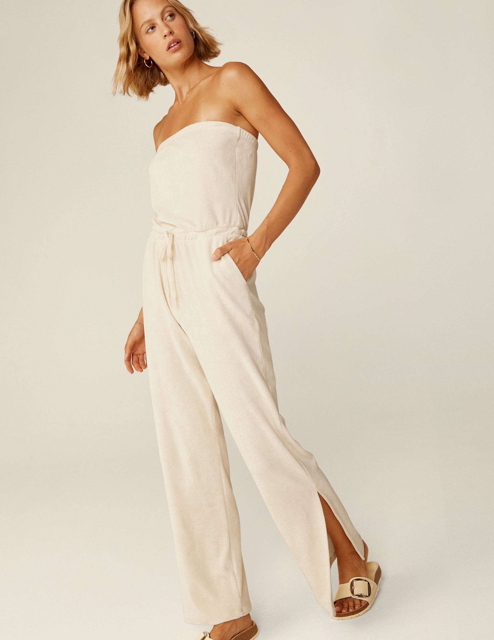 white strapless terry jumpsuit with a drawstring at the waistband. 