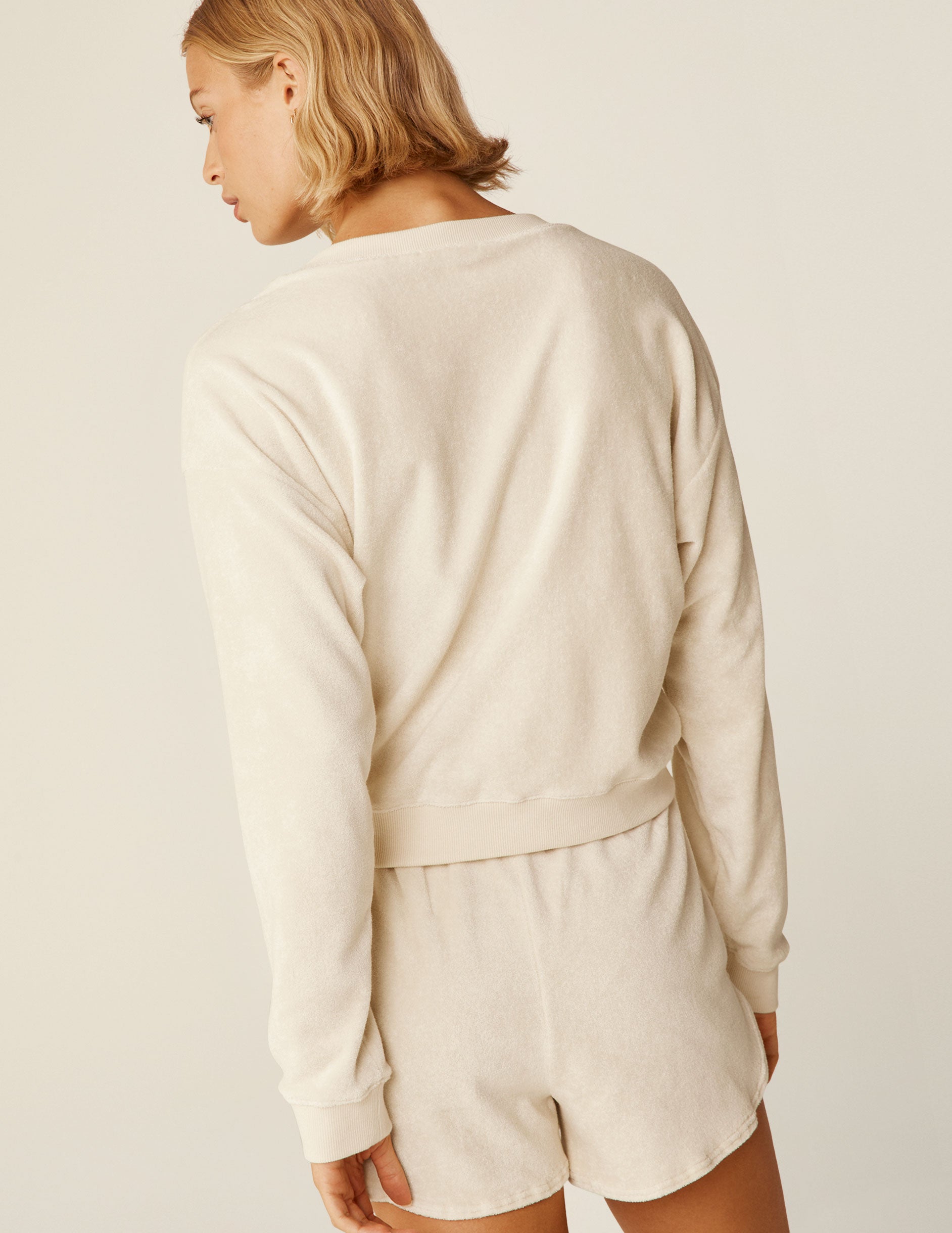 cream colored terry v-neck long sleeve pullover. 