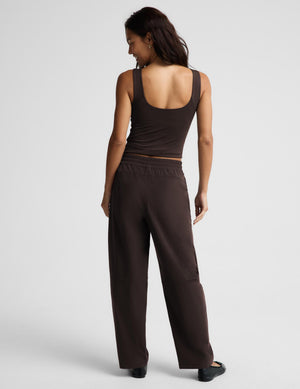A woman shown from the back wearing a dark brown tank top and matching wide-leg pants against a light gray studio background.