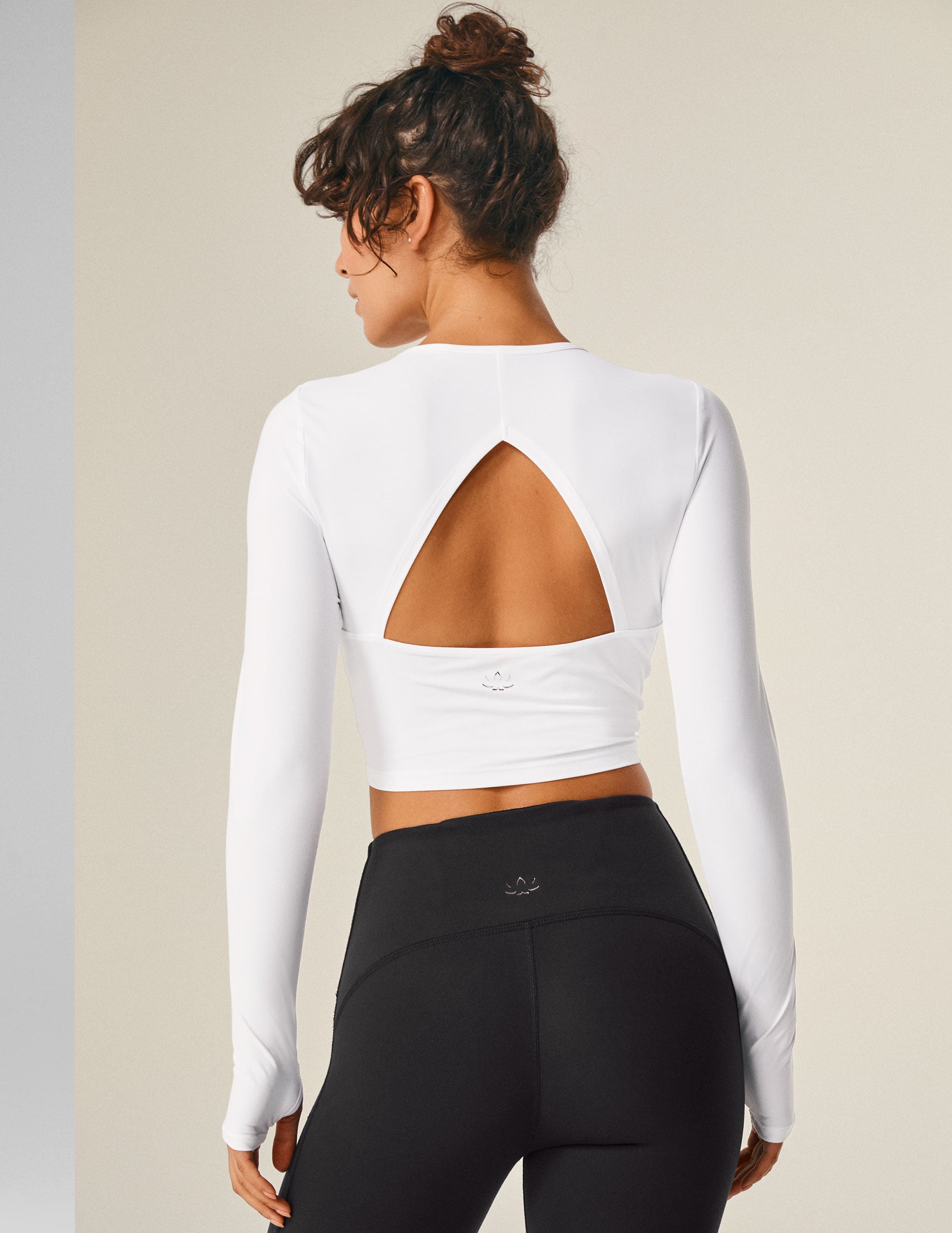 white long sleeve cropped top with an open back detail.