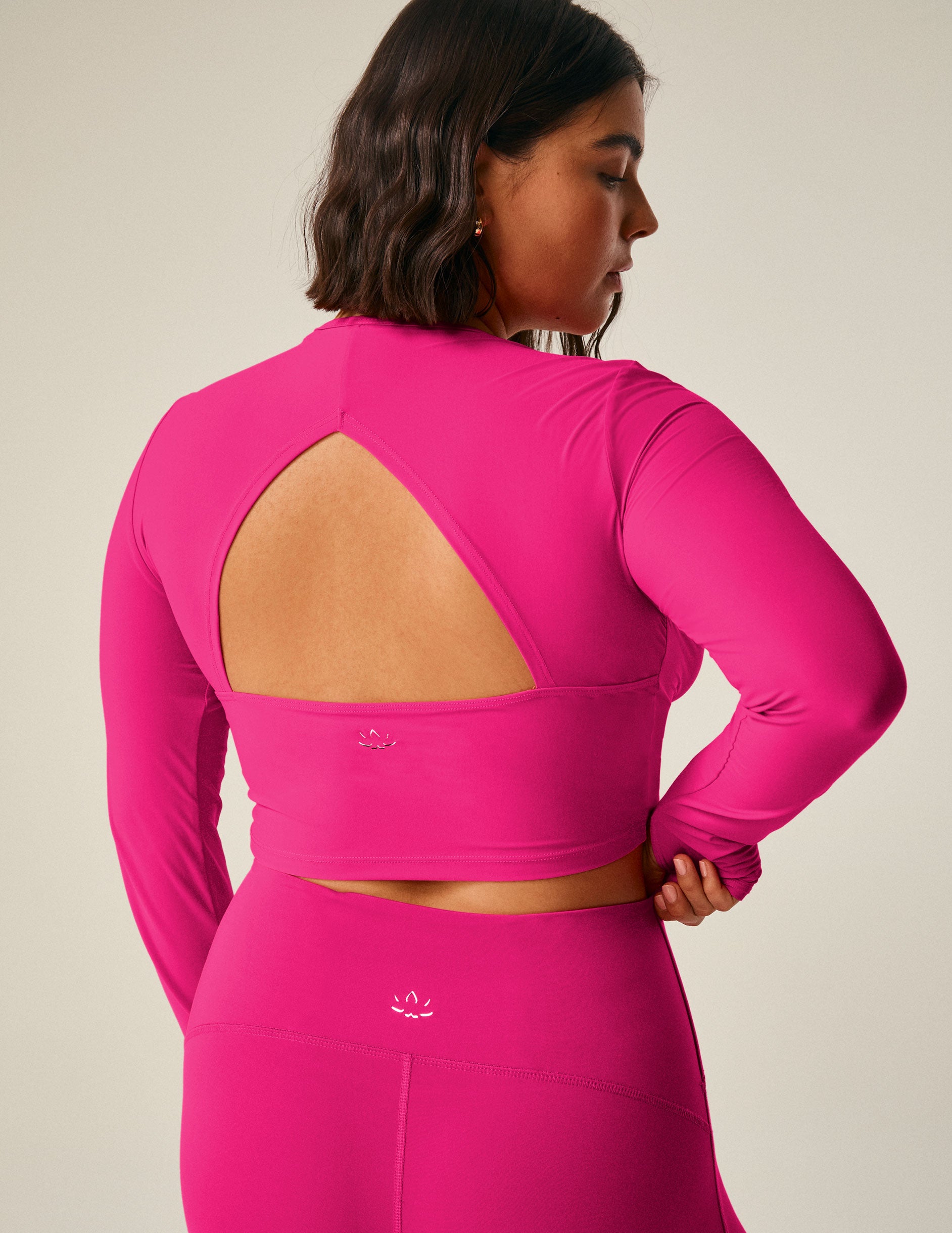 pink long sleeve cropped top with an open back detail.