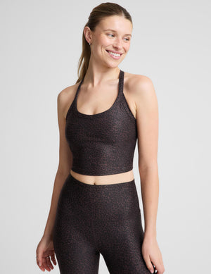 A woman modeling a matching activewear set featuring a dark brown and black leopard print cropped tank and high-waisted leggings, set against a plain light gray background.