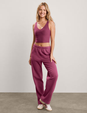 A blonde woman wearing a heathered mauve-purple ribbed crop top and matching jogger pants, photographed against a light gray studio background.